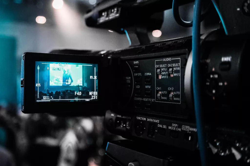 Professional video camera recording a live corporate seminar on stage